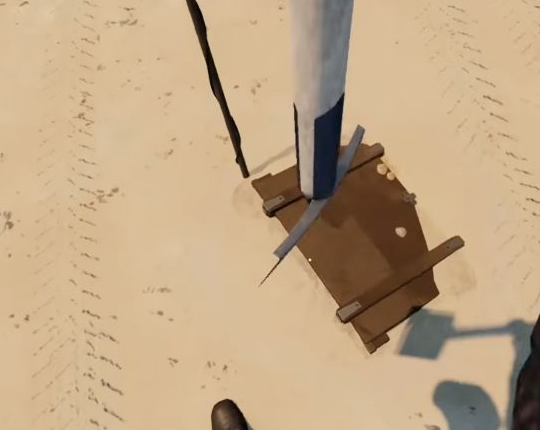 Shovel and newly exposed wooden chest in the sand